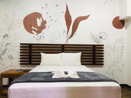 a bedroom with a bed with two white towels on it at Ávita Lodge in Quesada