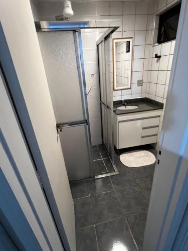 a bathroom with a shower and a sink at Apartamento Aconchegante - Boraceia (Bertioga) in Bertioga