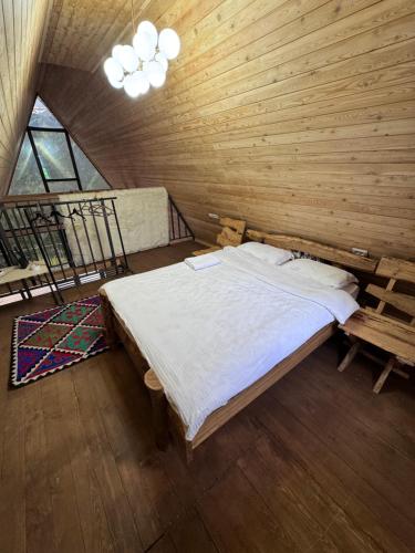ein Schlafzimmer mit einem großen Bett an einer Holzwand in der Unterkunft Super View-2 Bedroom Chalet Karakol in Karakol