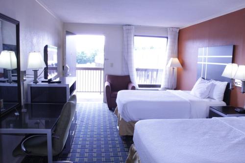 een hotelkamer met 2 bedden en een balkon bij Days Inn by Wyndham Salem in Salem