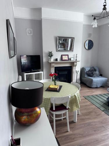 een woonkamer met een tafel en een televisie bij Superb Location 3 MIN TO RDS, AVIVA, D4 2 BED APARTMENT in Dublin