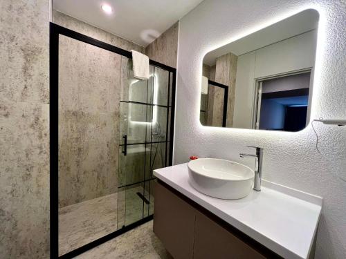 un baño con lavabo y espejo en Coastline, en Antalya