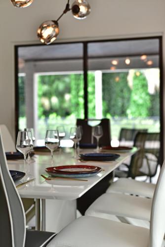 a dining table with wine glasses and chairs at Cozy home with big pool in Wellington! in Wellington