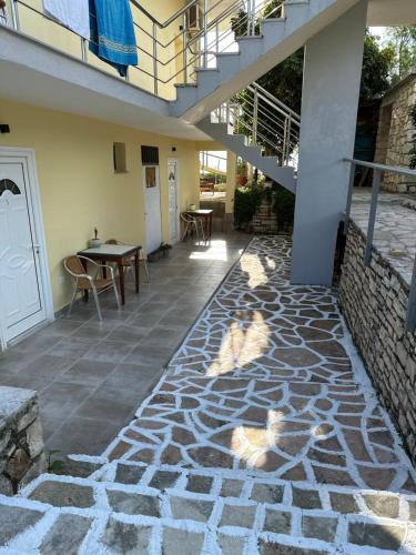 a patio with a staircase and a table and chairs at Potami Seashell in Himare