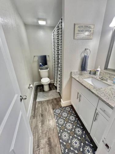 a small bathroom with a toilet and a sink at Lovely 2-bedroom condo next to AT&T Stadium in Arlington