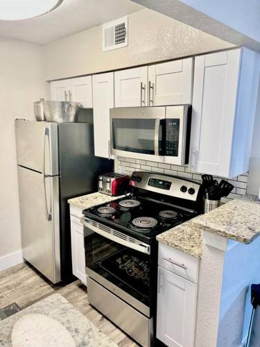 a kitchen with a stove and a refrigerator at Lovely 2-bedroom condo next to AT&T Stadium in Arlington