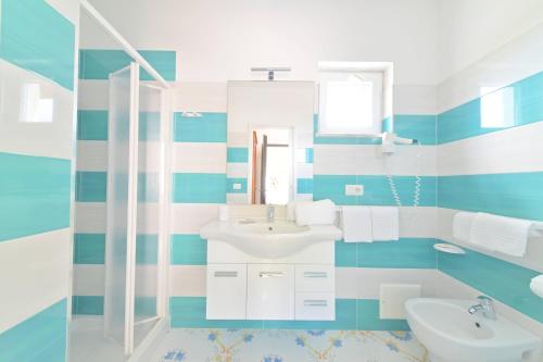 a blue and white bathroom with a sink and a mirror at Blu Maronti in Ischia
