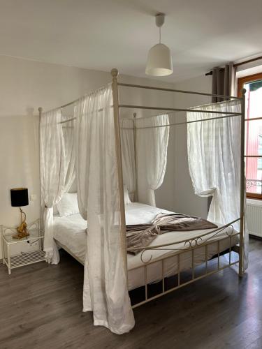 a bedroom with a canopy bed with white curtains at Hôtel de l'Espérance in Saint-Cast-le-Guildo