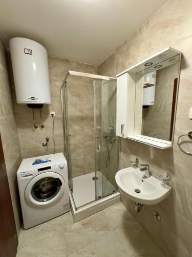 a bathroom with a washing machine and a sink at Cozy 1 bedroom APT with free parking in Podgorica