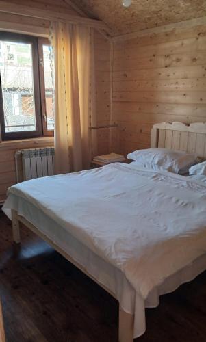 um quarto com uma cama branca num quarto de madeira em Green Dilijan wood em Dilijan