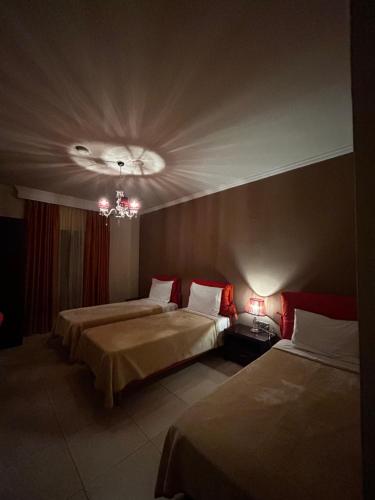 a hotel room with two beds and a chandelier at Faraggi Hotel in Simvolí