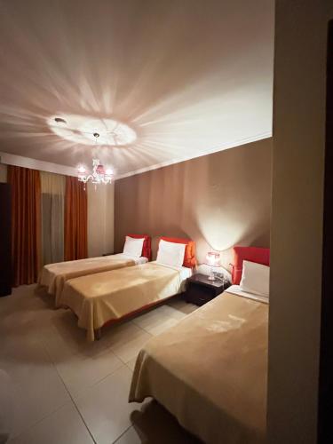 Habitación de hotel con 2 camas y lámpara de araña. en Faraggi Hotel, en Simvolí