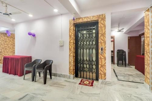 una sala de espera con sillas y una puerta negra en OYO Oxy Rudra Inn, en Ranchi