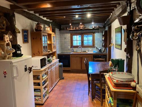 une cuisine avec un réfrigérateur et une table à l'intérieur dans l'établissement Maison au calme a la campagne, à Hermival-les-Vaux