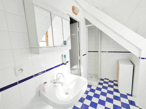 a bathroom with a sink and a blue and white checkered floor at Hôtel de l'Espérance in Saint-Cast-le-Guildo