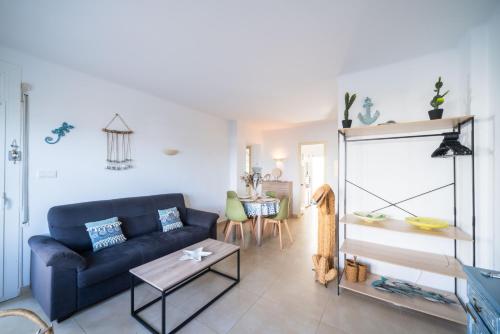 Una sala de estar con un sofá azul y una mesa. en Appartement Proche Mer - Roses, Manuel 10 by Welhomy, en Roses