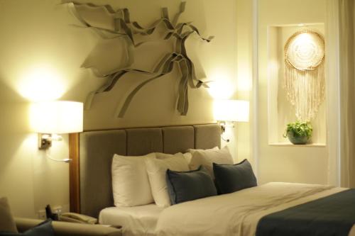 uma cama num quarto de hotel com dois candeeiros e um sidx da cama em Naay Tulum Curamoria Collection em Tulum