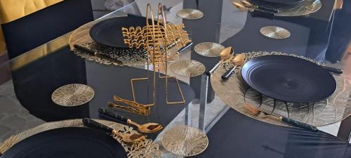 a glass table with plates and utensils on it at The Palm Villa in St Paul's Bay