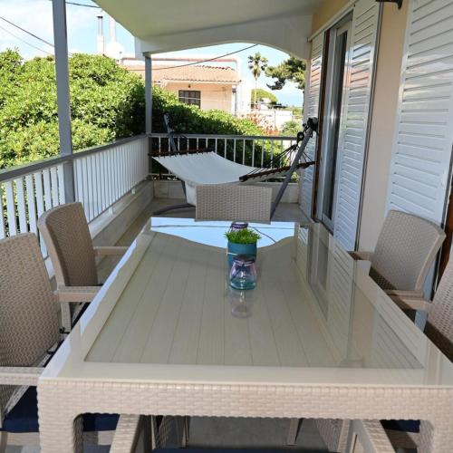 a table on a porch with chairs and an umbrella at Beverley's House Rio in Rio