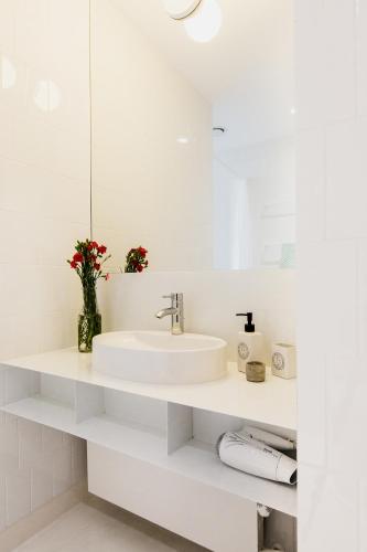 a white bathroom with a sink and a mirror at Apartamenty Browar Perła - free Parking in Lublin