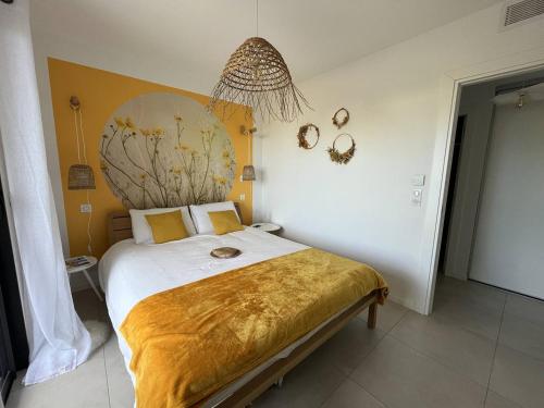 - une chambre avec un grand lit et une couverture en or dans l'établissement Appartement jardin de livia 2 rez de jardin, à Porticcio