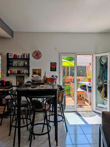 une salle à manger avec une table et des chaises noires dans l'établissement Appartement près de la plage, un coin paradis !, à Frontignan