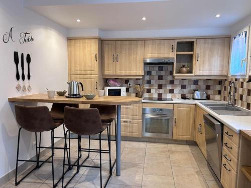 a kitchen with a table and some chairs in it at Maison le ptit chez nous in Pontaubert