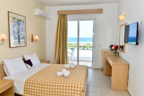 a hotel room with a bed and a view of the ocean at Summer View in Theologos