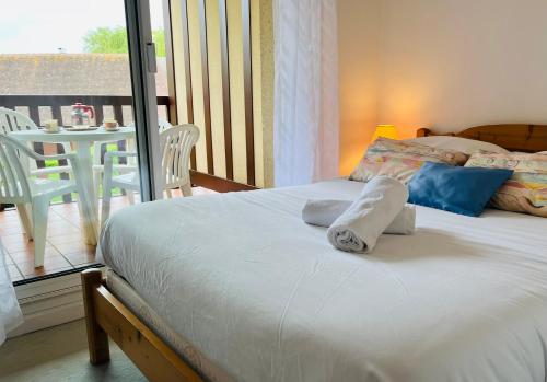 une chambre avec un lit et un balcon avec une table dans l'établissement Butterfly Deauville, à Deauville