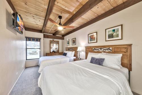 - 2 lits dans une chambre dotée de plafonds en bois dans l'établissement Lakeland Village 495 - Stellers Jay’s Nest Hot Tubs Beach, à South Lake Tahoe