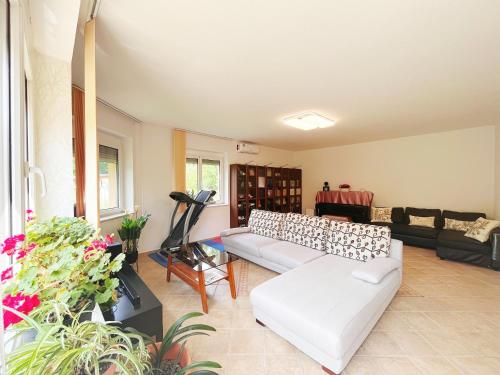 uma sala de estar com um sofá branco e uma mesa em Garden villa em Budapeste
