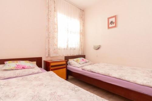- une chambre avec 2 lits et une fenêtre dans l'établissement Beautiful Apt Barby near Queen Beach, à Privlaka