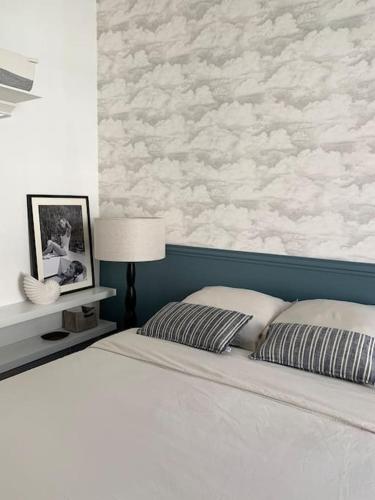 - une chambre avec un lit et un mur avec des nuages dans l'établissement Retour de plage Wimereux, à Wimereux