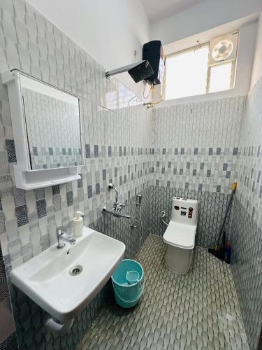 a bathroom with a sink and a toilet at LOFTEL STAYS in Hyderabad
