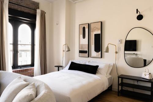 a bedroom with a large white bed and a mirror at Maison Place Jacques-Cartier by Luxury In Transit in Montréal