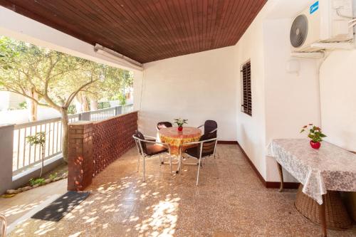 Cette chambre dispose d'un balcon avec une table et des chaises. dans l'établissement Beautiful Apt Barby near Queen Beach, à Privlaka