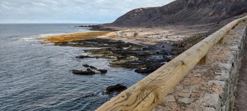 - Vistas a una playa con una valla de madera en BKD1 - Apartamento entero a 50 metros PLAYA DE LAS CANTERAS, en Las Palmas de Gran Canaria