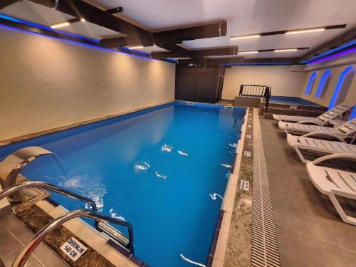 uma grande piscina com cadeiras num quarto em Sera Lake Center Hotel em Trabzon