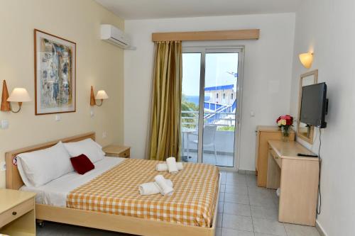 a hotel room with a bed and a balcony at Summer View in Theologos