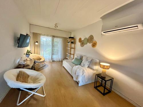 ein Wohnzimmer mit einer weißen Couch und einem Stuhl in der Unterkunft Puerta Azul in Punta del Este