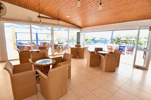 a restaurant with chairs and tables and windows at Summer View in Theologos