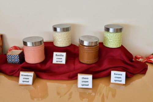 a table with four jars on a red table cloth at Summer View in Theologos