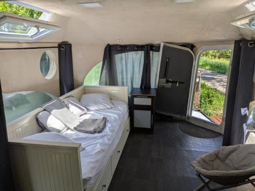 une chambre avec un lit et une télévision dans un camping-car dans l'établissement Bateau studio terrasse vue sur l'eau et nature, à Saint-Usage