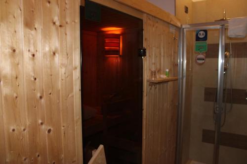 Łazienka z prysznicem i drewnianą ścianą w obiekcie Brain Rooms & Suite w mieście Pagani