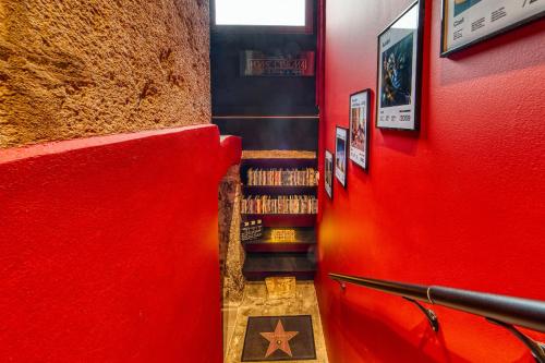 un couloir rouge avec un mur rouge et un escalier avec des livres dans l'établissement Movie Room Immersion unique et atmosphère cosy assurée, à Lyon