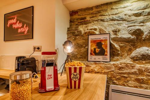 Cette chambre comprend une table avec du pop-corn et un mur en pierre. dans l'établissement Movie Room Immersion unique et atmosphère cosy assurée, à Lyon