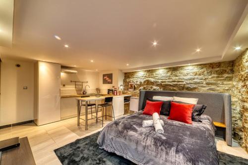 une chambre avec un grand lit avec des oreillers rouges dans l'établissement Movie Room Immersion unique et atmosphère cosy assurée, à Lyon