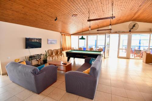 a living room with couches and a pool table at Summer View in Theologos