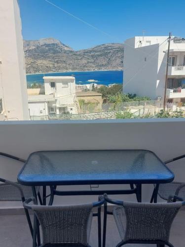 a table and chairs on a balcony with a view of the ocean at Anesis Luxury Hospitality in Karpathos Town