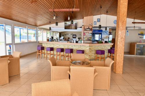 a restaurant with a bar with purple chairs at Summer View in Theologos